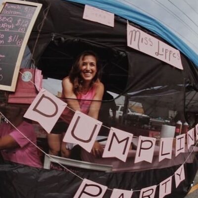 woman smiling from dumpling party food booth